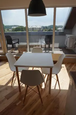a table and chairs in a room with a large window at Napoleon Hill Apartment in Kaunas