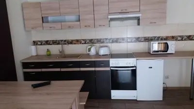 a kitchen with a white stove and a microwave at Šeimyninis butas in Birštonas