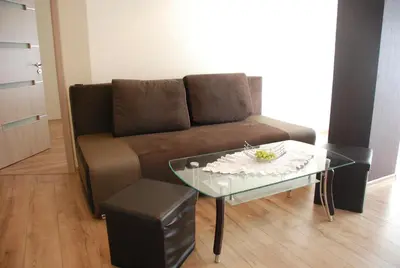 a living room with a couch and a glass table at Šeimyninis butas in Birštonas