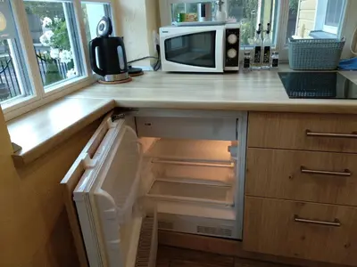 a kitchen with a microwave and an open refrigerator at Manto Apartamentai in Druskininkai