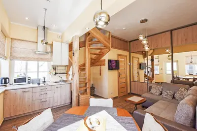 a kitchen and living room with a couch and a table at Manto Apartamentai in Druskininkai