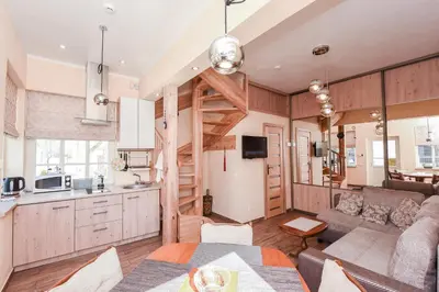 a kitchen and living room with a couch and a table at Manto Apartamentai in Druskininkai