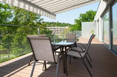 a patio with a table and chairs on a balcony at Central Apartment in Birštonas