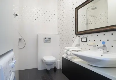 a white bathroom with a sink and a toilet at Central Apartment in Birštonas