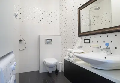 a white bathroom with a sink and a toilet at Central Apartment in Birštonas