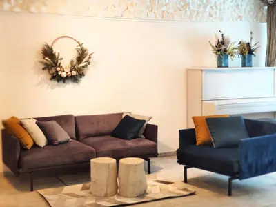 a living room with a brown couch and two chairs at Family house in Druskininkai