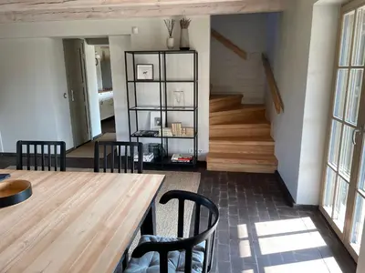 a dining room with a wooden table and chairs at Kuliniai by Stirniai lake Moletai district in Kulintse