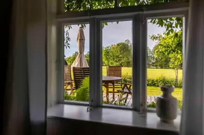 an open window with a table and an umbrella at Kuliniai by Stirniai lake Moletai district in Kulintse
