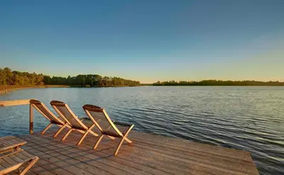 two chairs sitting on a dock on a lake at Kuliniai by Stirniai lake Moletai district in Kulintse