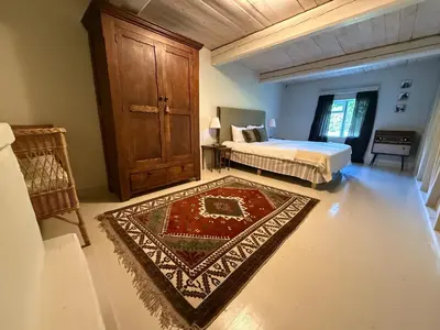 a bedroom with a bed and a rug at Kuliniai by Stirniai lake Moletai district in Kulintse