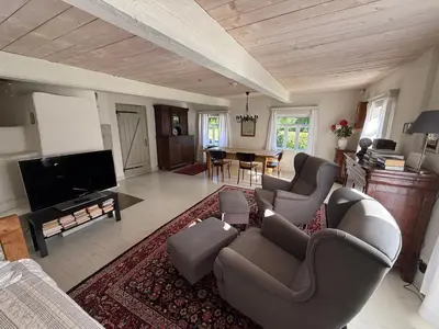a living room with couches and a flat screen tv at Kuliniai by Stirniai lake Moletai district in Kulintse