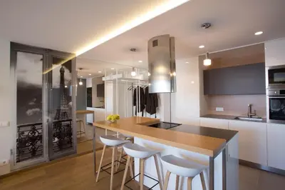 a kitchen with a wooden counter and stools at Angel in Druskininkai