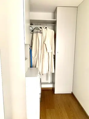 a closet with a white door and a coat hanging at Angel in Druskininkai