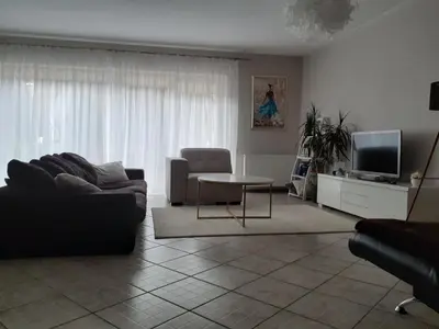 a living room with a couch and a table and a tv at Apartments near old town with private parking in Kaunas