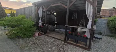 a black shed with a porch with a bench and flowers at Apartments near old town with private parking in Kaunas