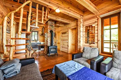 a living room with a couch and chairs in a log cabin at Mekų sodyba in Degučiai