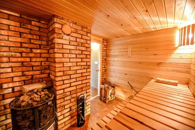 an empty wooden sauna with a bench and a fireplace at Mekų sodyba in Degučiai
