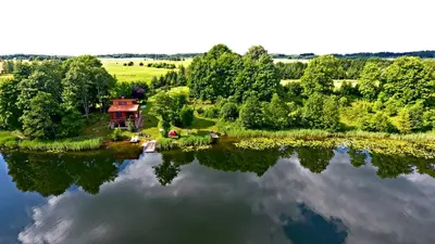 an island in the middle of a lake with a house at Mekų sodyba in Degučiai