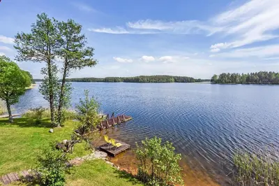 a group of benches sitting on the shore of a lake at Mekų sodyba in Degučiai