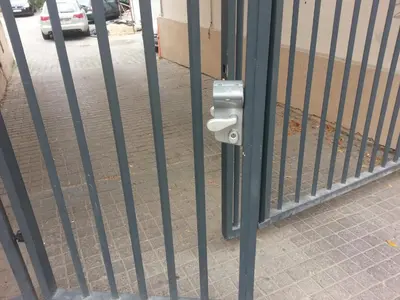 a gate with a lock on the side of a street at Apartment Vilnius Zemaitijos in Vilnius