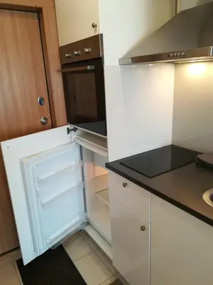 a small white kitchen with a glass refrigerator at Apartment Vilnius Zemaitijos in Vilnius