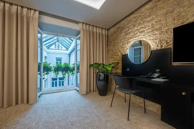 a room with a desk and a mirror and a window at Artagonist Art Hotel in Vilnius