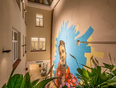 a mural on a wall in a room with plants at Artagonist Art Hotel in Vilnius