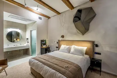 a bedroom with a bed and a mirror on the wall at Artagonist Art Hotel in Vilnius
