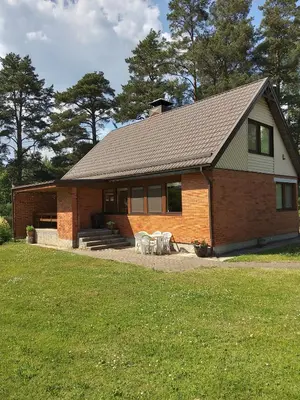 a brick house with tables and chairs in front of it at Petronių sodyba in Rukliai