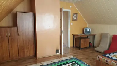 a small living room with a bed and a tv at Petronių sodyba in Rukliai