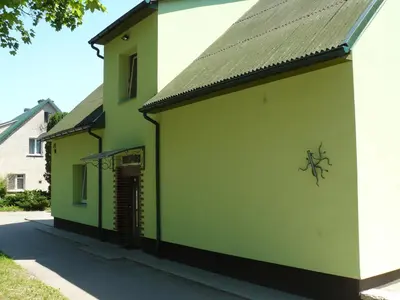 a green building with graffiti on the side of it at Centro bustas in Kėdainiai