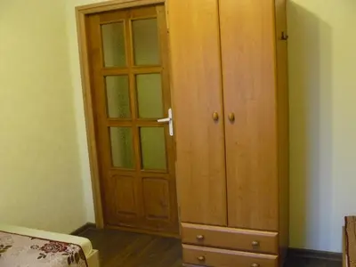 a wooden cabinet in a room with a bedroom at Centro bustas in Kėdainiai