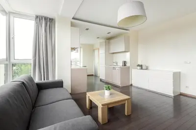 a living room with a couch and a table at Zalgirio apartment in Vilnius