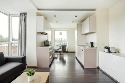 a kitchen and living room with a couch and a table at Zalgirio apartment in Vilnius