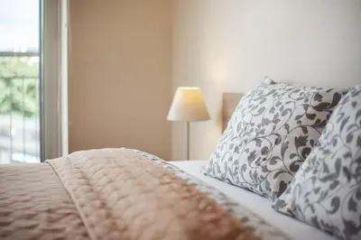 a bedroom with a bed with a pillow and a lamp at Zalgirio apartment in Vilnius