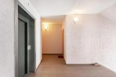 an empty hallway with a door and a tile floor at Zalgirio apartment in Vilnius