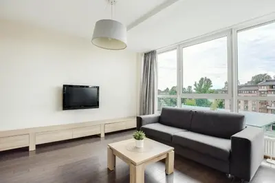 a living room with a couch and a tv at Zalgirio apartment in Vilnius