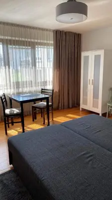 a bedroom with a table and chairs and a bed at Apartamentai Tarp trijų ežerų in Tytuvėnai