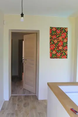 a kitchen with a painting hanging on the wall at Apartamentai Tarp trijų ežerų in Tytuvėnai