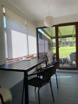 a dining room with a table and a chair at Apartamentai Tarp trijų ežerų in Tytuvėnai