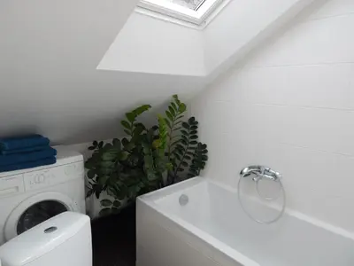 a white laundry room with a washer and dryer at ROKO Apartments in Kaunas