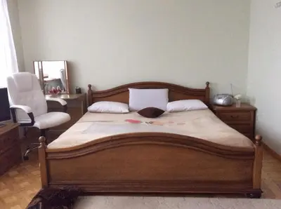a bedroom with a bed with a chair and a mirror at Kotedžai Milikonių g. in Kaunas