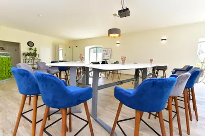 a dining room with a table and blue chairs at Auroradream in Motiejiškės