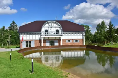 a large building with a pond in front of it at Auroradream in Motiejiškės