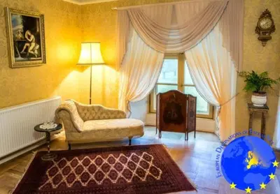 a living room with a couch and a chair at Pakruojis Manor's Palace Boutique Hotel in Pakruojis