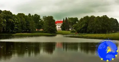 a large white house sitting on top of a lake at Pakruojis Manor's Palace Boutique Hotel in Pakruojis