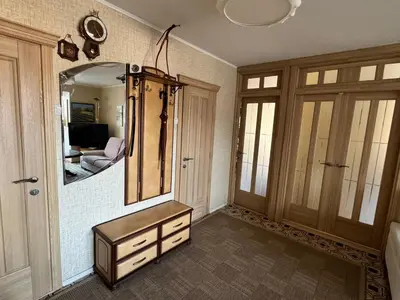 a bathroom with a dresser and a large mirror at VIsagino Apartment in Visaginas