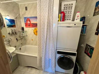 a bathroom with a washer and a washing machine at VIsagino Apartment in Visaginas