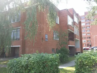a brick building with a sign on the side of it at VIsagino Apartment in Visaginas