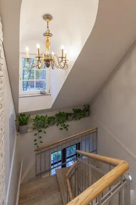 a staircase with a chandelier and potted plants at Apartments Satva in Vilnius